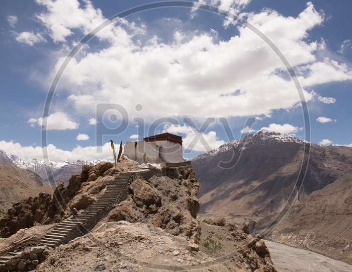 Hindu Temples On The Terrains With Sedimentary Hills and Cotton Candy Clouds In Background  in Spiti Valley