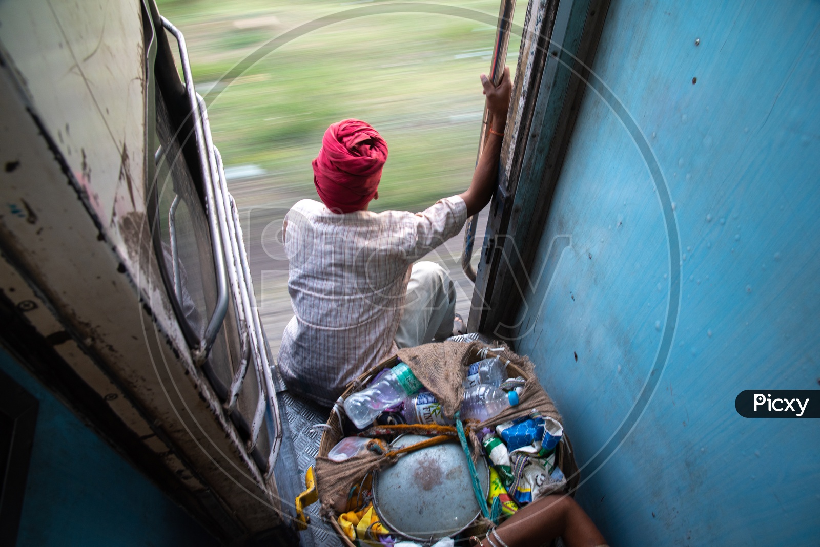A Rag Picker In Indian Train Sitting at a Door Step While train  Moving
