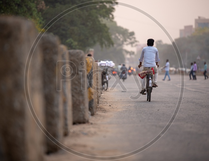 A Man Using Bicycle For The Commuting In  City Roads