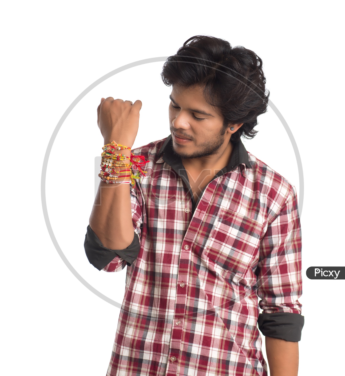 A Young Indian Man With a Elegant Rakhis Tied To His Hand And Posing Over a White Background