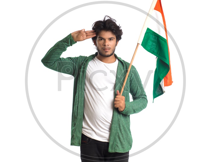 A Young Indian man Holding  Indian National Flag ( Tri Color )  In Hands And With a  Saluting Pose  Over a White Isolated Background