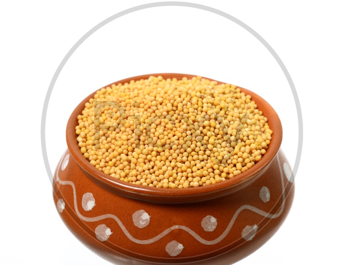yellow mustard seeds in a bowl isolated on white background