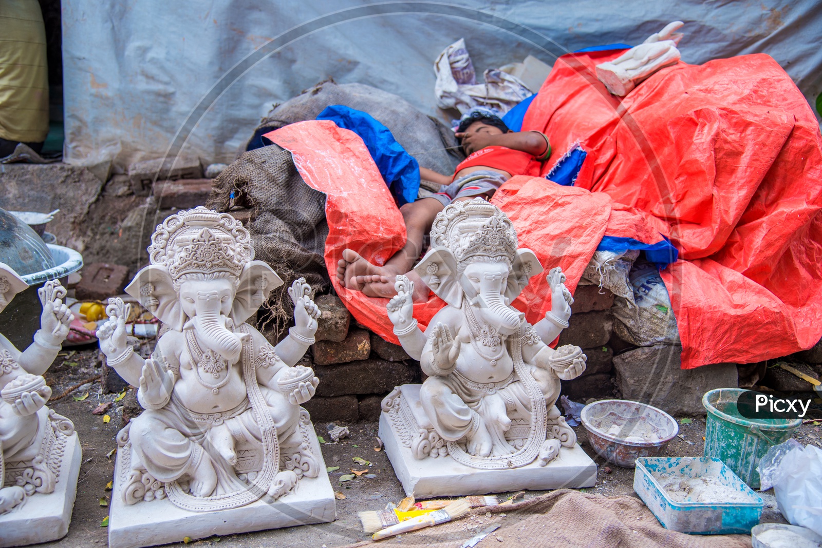 A Child Sleeping At a Workshop Of Ganesh Idol Making