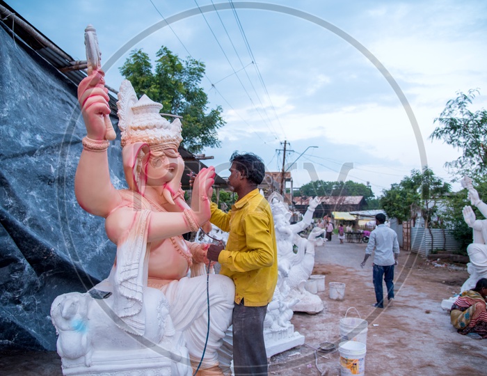 Indian man painting the Lord Ganesha Idol