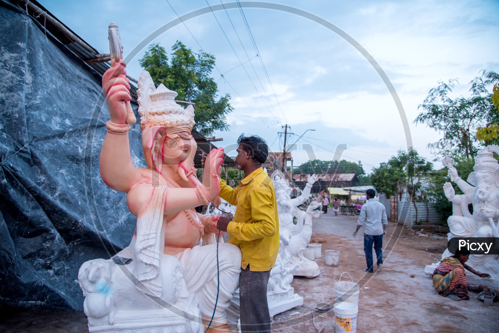 Indian man painting the Lord Ganesha Idol