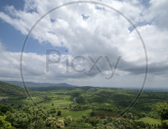 A Landscape With Aerial View of Agricultural Fields , Hills And Blue Sky With Cotton Clouds