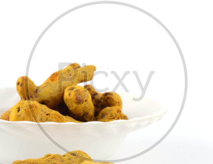 Dry Turmeric Roots Or Barks  In a Bowl On an Isolated White Background