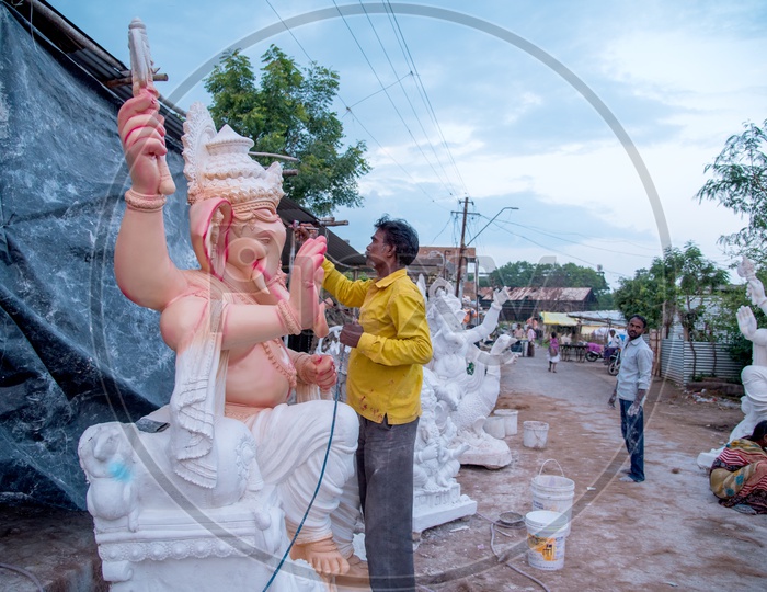 Indian Artist painting the Lord Ganesha Idol