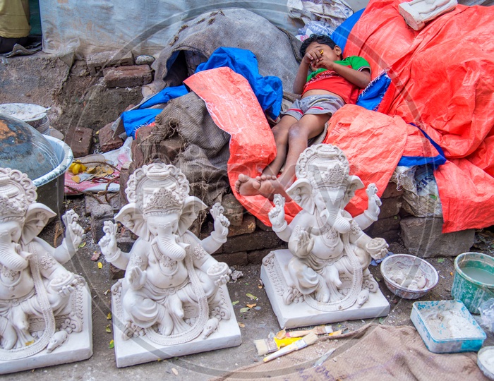 A Child Sleeping At a Workshop Of Ganesh Idol Making