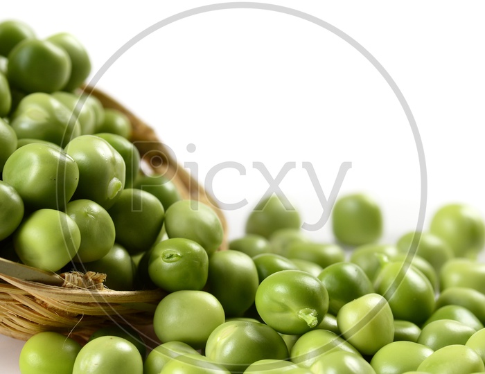 Fresh Green Peas in a Wooden Weaved basket on an Isolated  white background