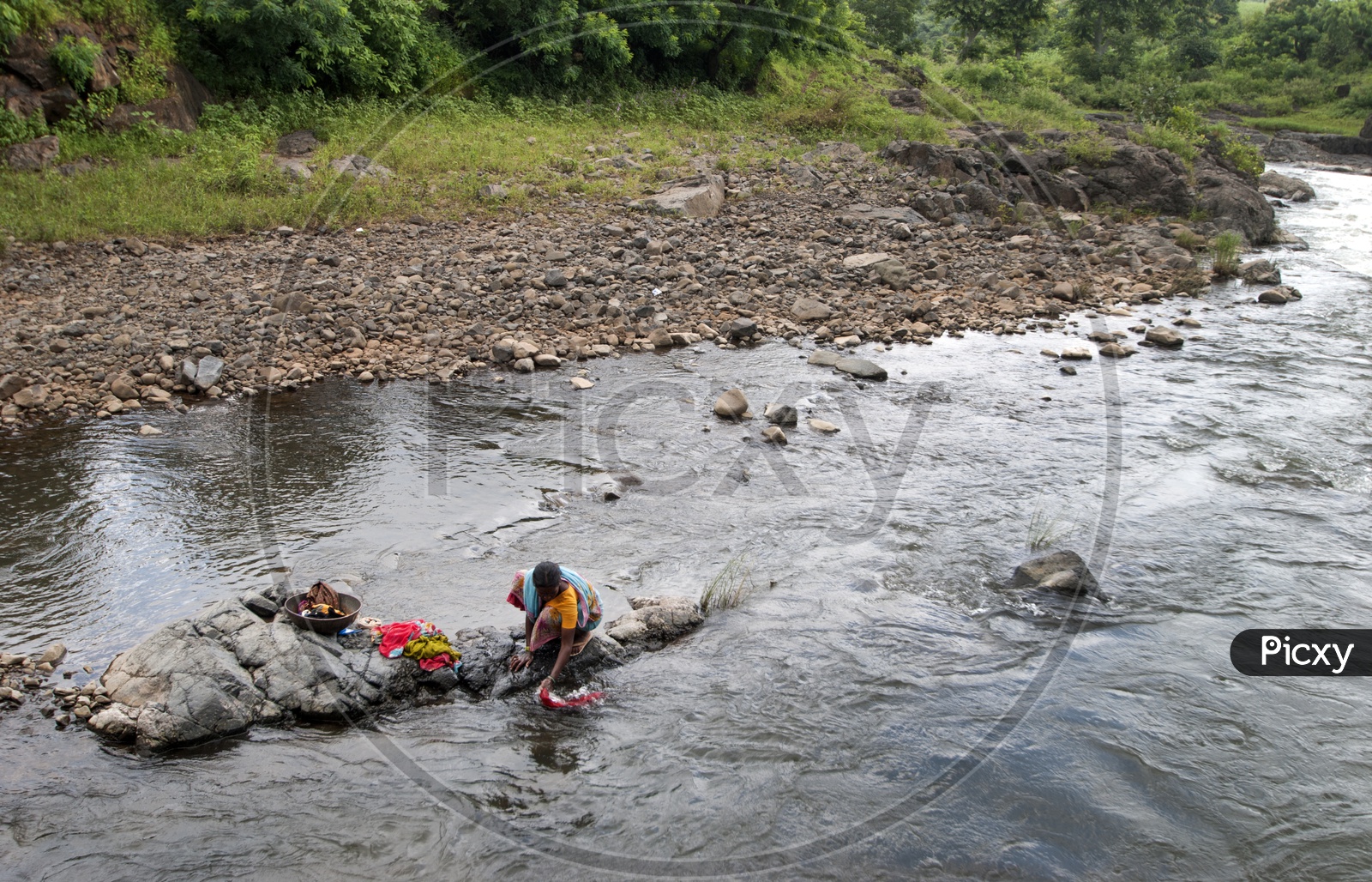 A Tribal Woman Washing Clothes In The Water Channels In The Tribal Villages