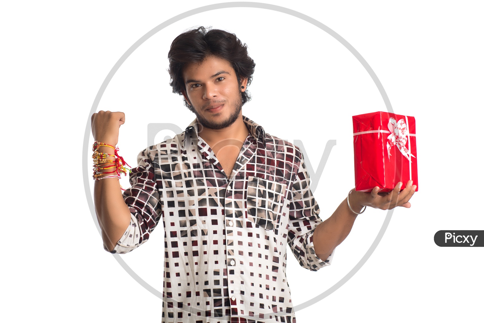 Indian Young Man Showing Rakhi Tied Hand And  with  a Gift Box For his Sister  On an  Isolated White Background