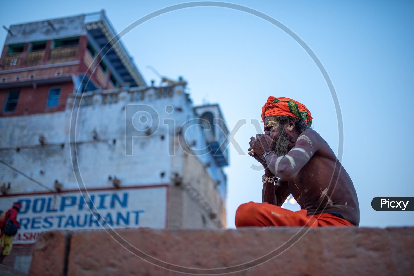 An Indian Baba Or Sadhu Blowing Shank or Shankham or  Sea Shell  In Varanasi