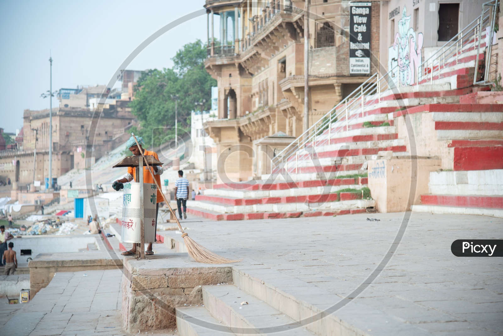 A  Municipal Corporation Worker Throwing The Trash in Dustbins On Ghats Of Varanasi