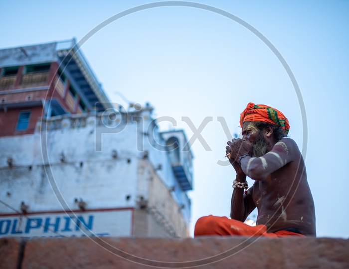 An Indian Baba Or Sadhu Blowing Shank or Shankham or  Sea Shell  In Varanasi