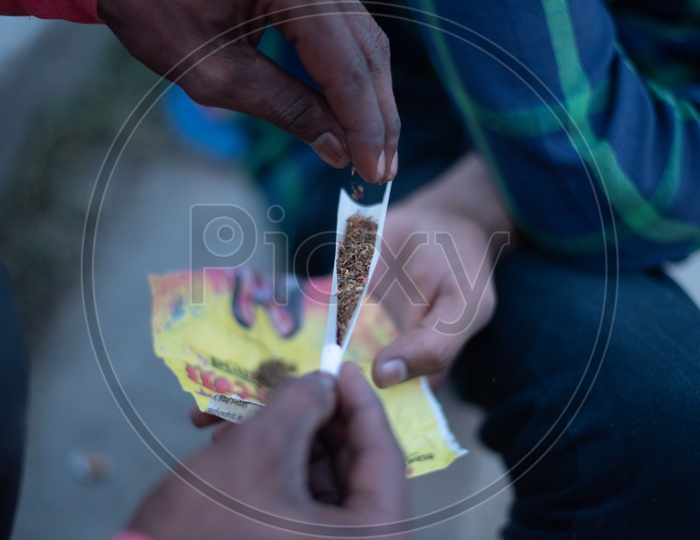 An  Indian Man Making A Cigar Or Joint  With Marijuna Or Weed Or Ganja  Closeup