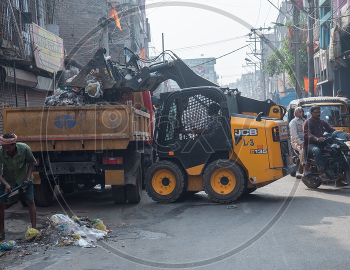 Municipal  Corporation  Workers  Cleaning  The Garbage With The help Of JCB Movers  On the Streets of  City