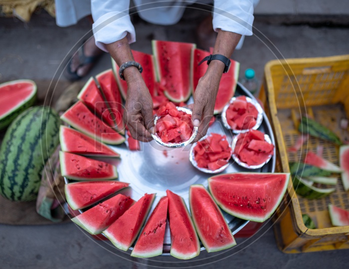 A Street Food Vendor Selling The Watermelon Pieces  At A Vendor Stall