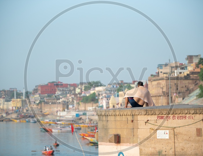 A Local Or Visitor Sitting On a The Bank Of River Ganga At a Ghat in Varanasi