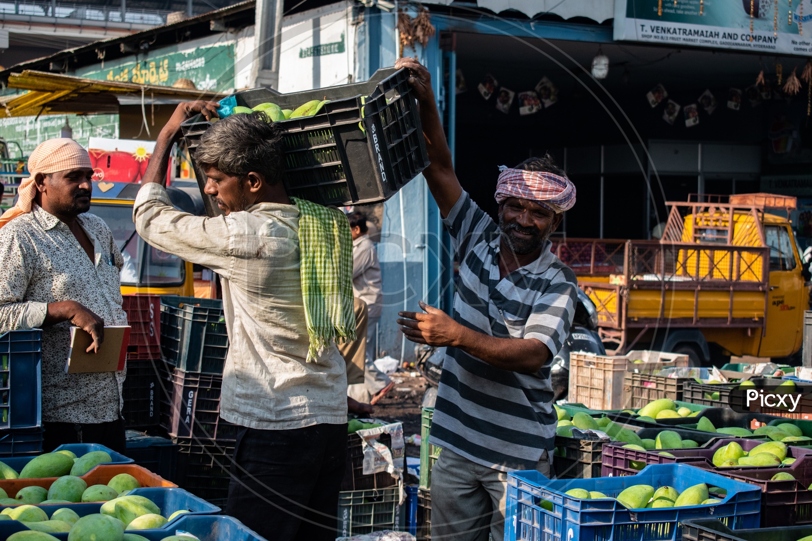 Image of Workers carrying the mango baskets at Kothapet Fruit market