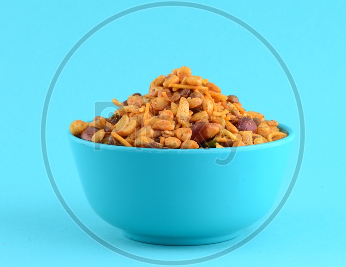 Indian Snack , Salty Deep Fried Chivda Or Mixture In a  Blue Bowl On an Isolated Blue   Background