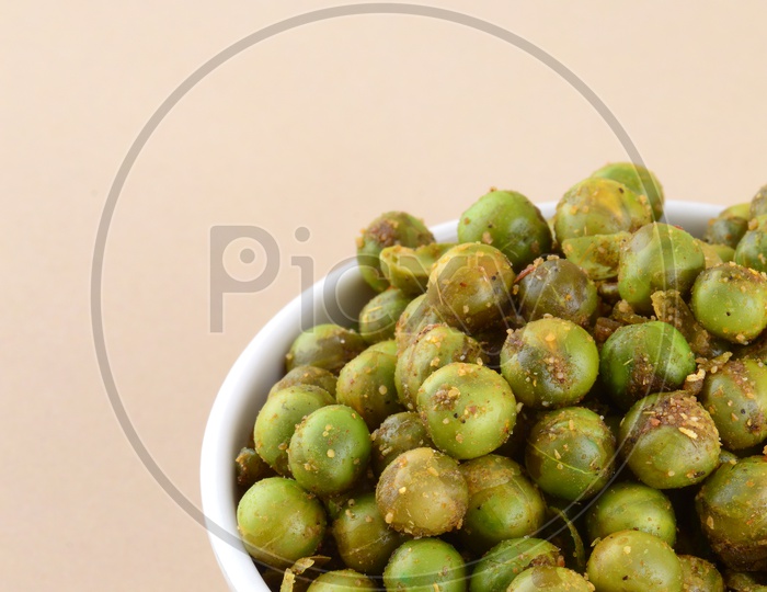 Indian Snack Salty Deep Fried Masala Green Peas  In a White Bowl On an Isolated Background