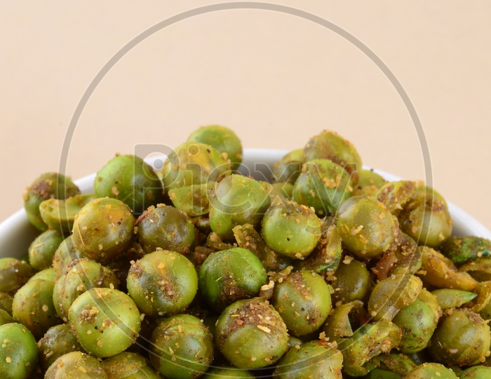 Indian Snack Salty Deep Fried Masala Green Peas  In a White Bowl On an Isolated Background