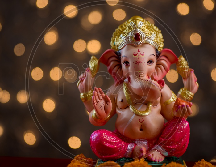 Indian Hindu God, Lord Ganesh Idol For  Pooja For Ganesh Chathurdhi  On an Isolated Led Light Bokeh  Background