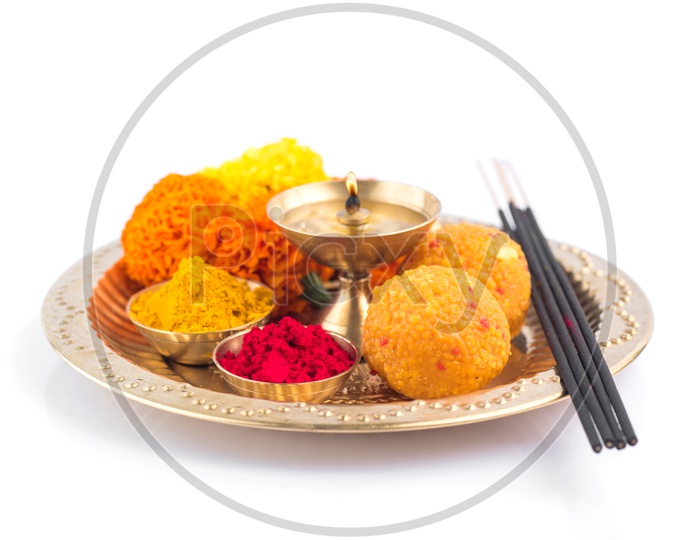 Indian Hindu Pooja Plates Or Thali With Diya , Kumkum , Sweet , Flower And Fragrance Sticks Or Agarbatti  On an Isolated White Background