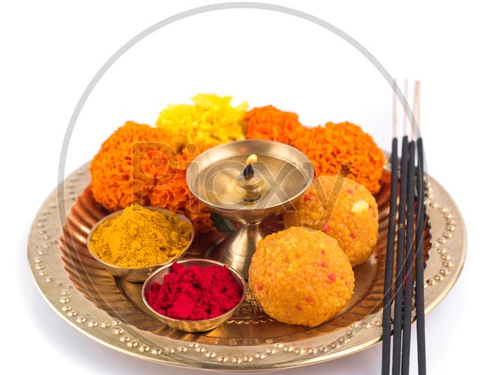 Indian Hindu Pooja Plates Or Thali With Diya , Kumkum , Sweet , Flower And Fragrance Sticks Or Agarbatti  On an Isolated White Background