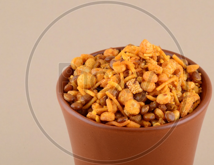 Indian Snack Deep Fried Salty Chivda Or Mixture In a Clay Pot On an Isolated Background