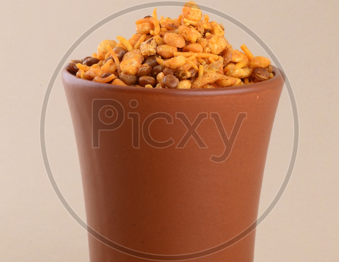 Indian Snack Deep Fried Salty Chivda Or Mixture In a Clay Pot On an Isolated Background