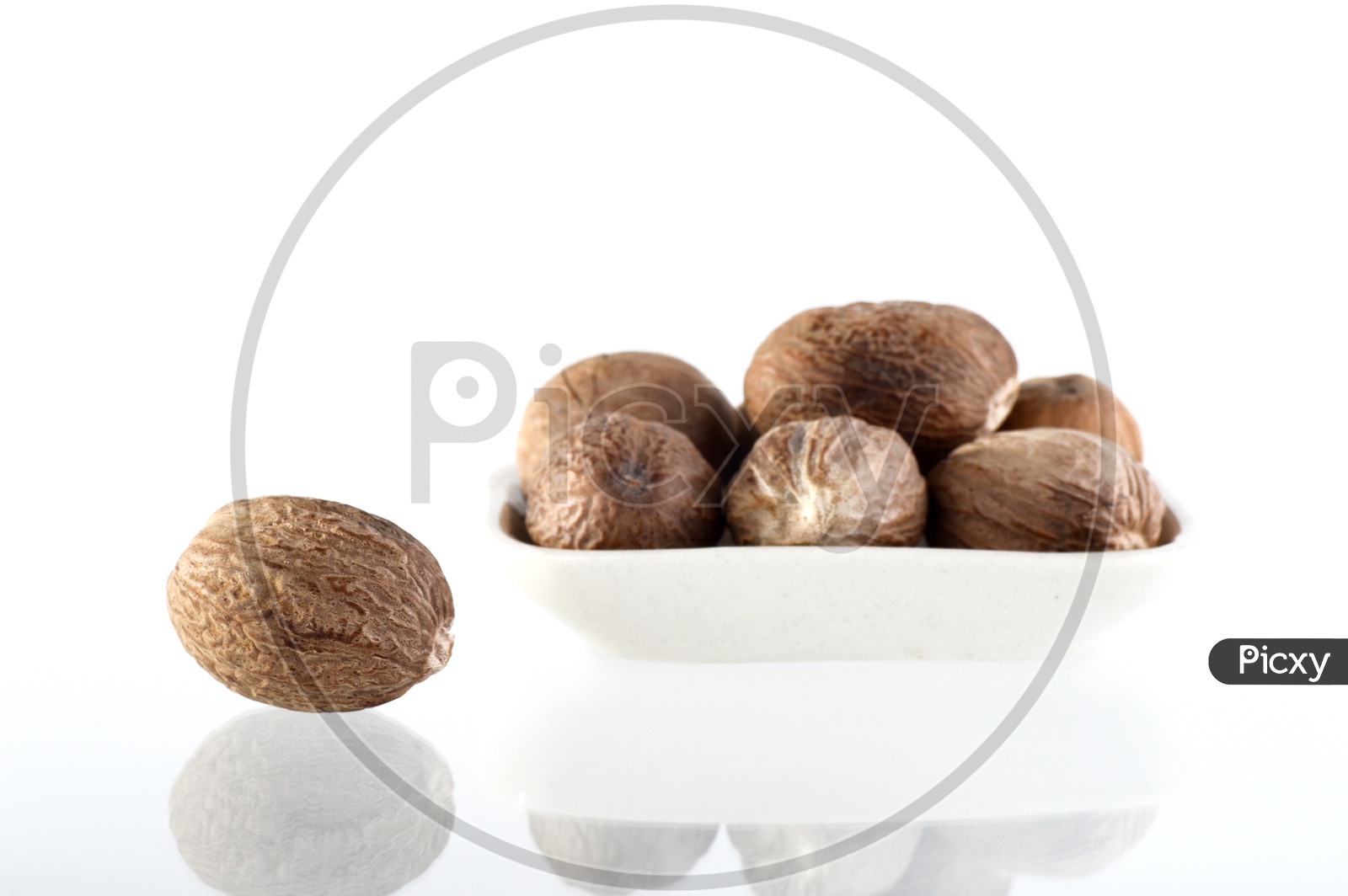 Image of Indian Spice Nutmeg in a Bowl On an Isolated White Background