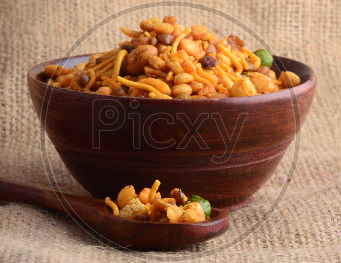 Indian Snacks , Salty Deep Fried Mixture Or Chivda In a Wooden Bowl On a Sack Cloth Background