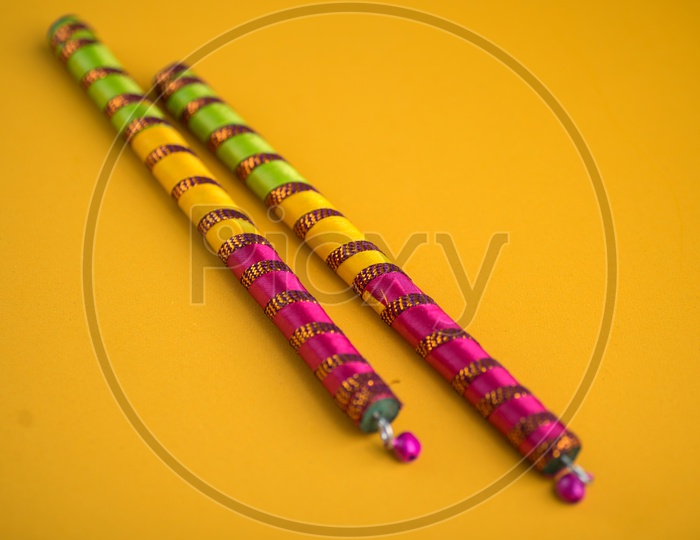 Dandiya  Sticks On An Isolated Yellow Background