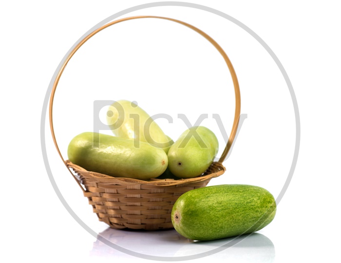 Fresh Green Cucumber Vegetable in a Wooden Weaved Basket On an Isolated White Background
