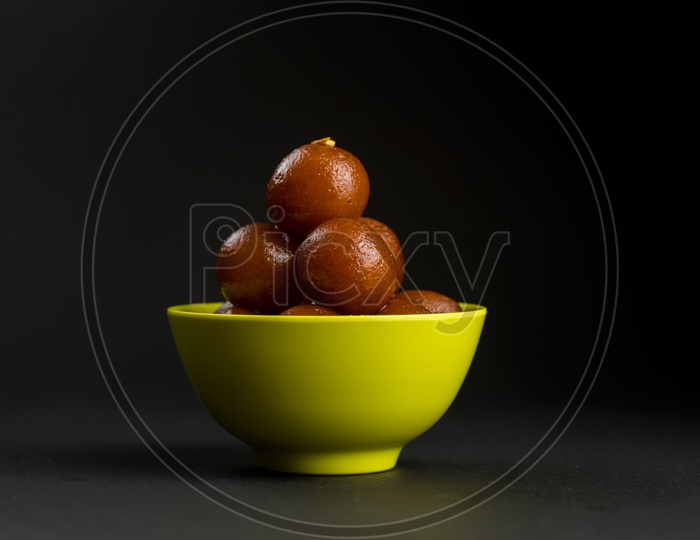 Indian Sweet or Dessert or Savoury Gulab Jamun  in a Bowl On an Isolated Black  Background
