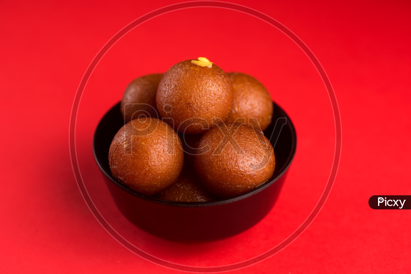 Indian Sweet or Dessert or Savoury Gulab Jamun  in a Bowl On an Isolated Red  Background