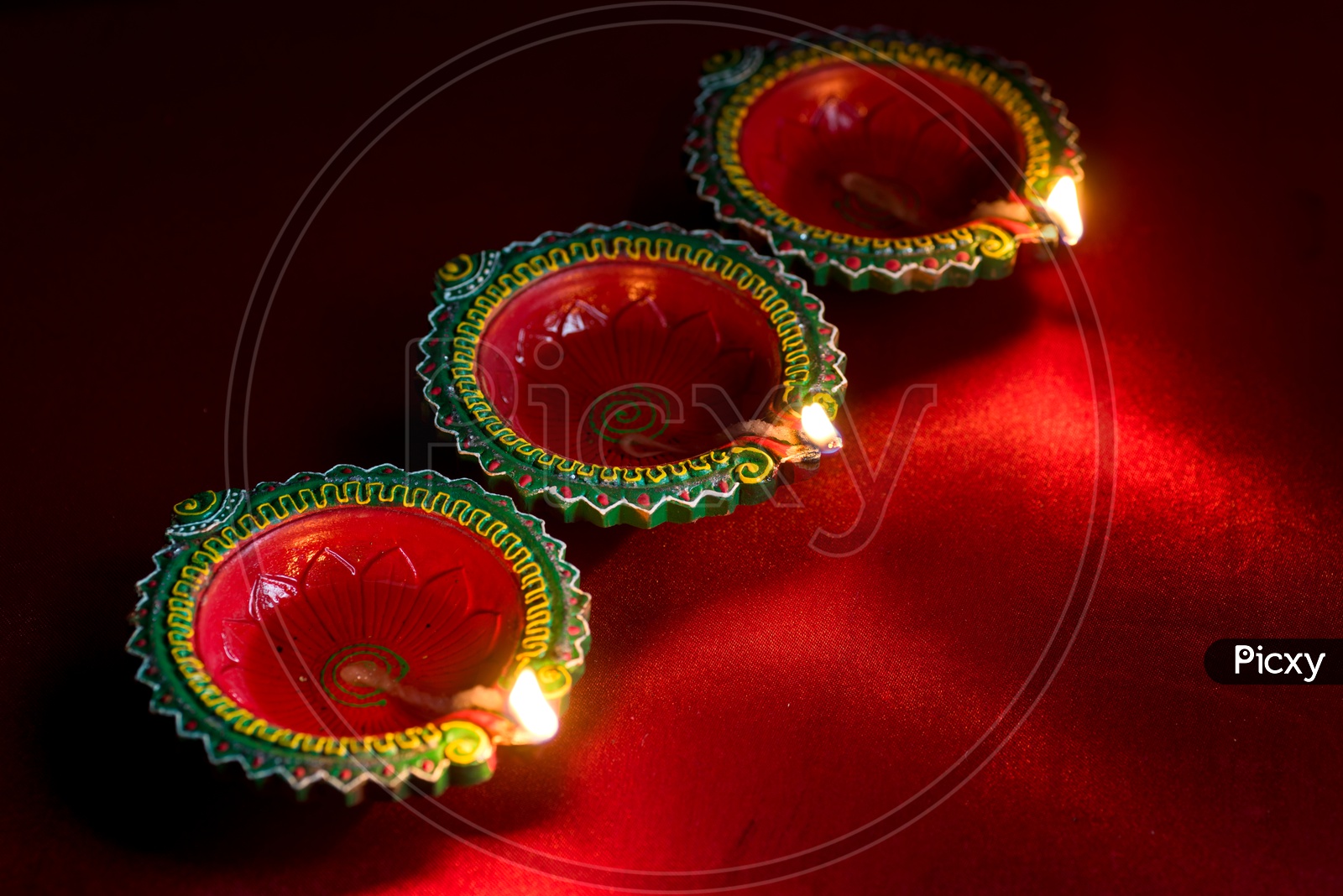 Indian Traditional Diwali Diyas Lighted on an Isolated Red Background For Diwali Wishes Or  Festival Message Template