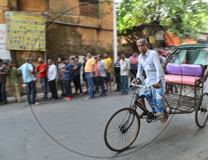 An Old Man  Riding A Rickshaw  on The Roads