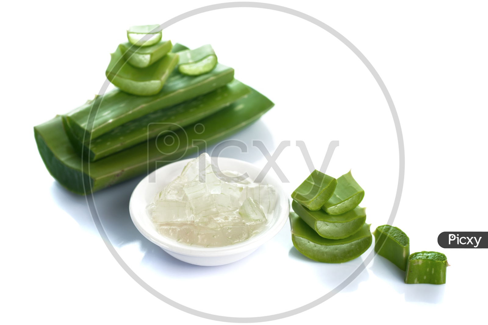 Extracted Aloe Vera Gel In an White Bowl Along With Aloe Vera Pieces on an Isolated White Background