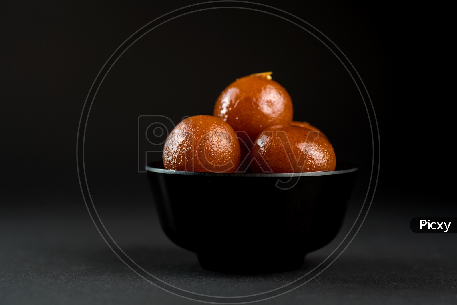 Indian Sweet or Dessert or Savoury Gulab Jamun  in a Bowl On an Isolated Black  Background