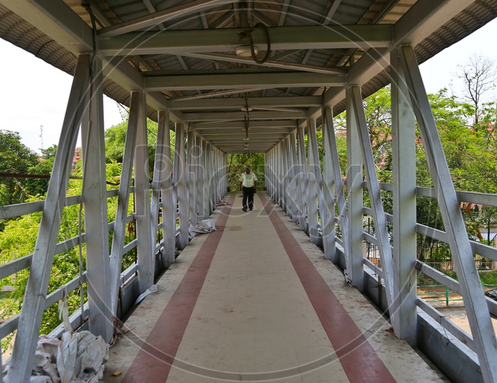 A Man Walking Alone On Foot Over Bridge
