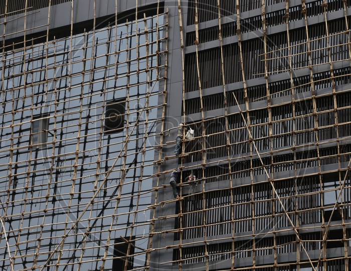 Construction Workers  Working At  a Facade of Building Risking Their Lives