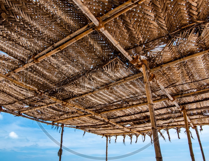 A Fisherman  Weaving Fishing Net By Sitting Under a Hut or Shed in a Beach