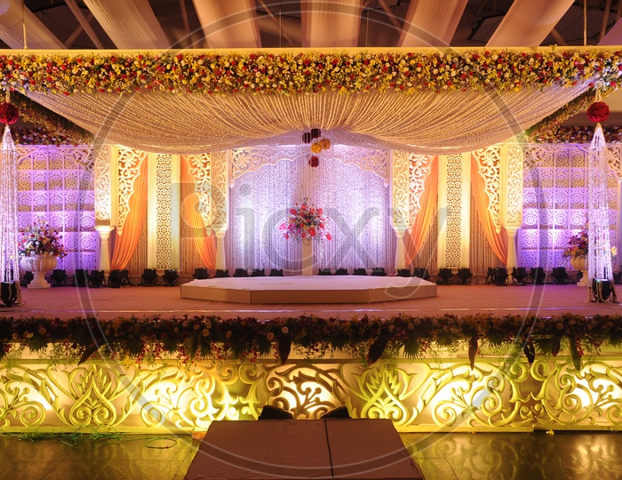 Beautifully Decorated Stage  Of a Convection Center With Fresh Flowers  for a Event