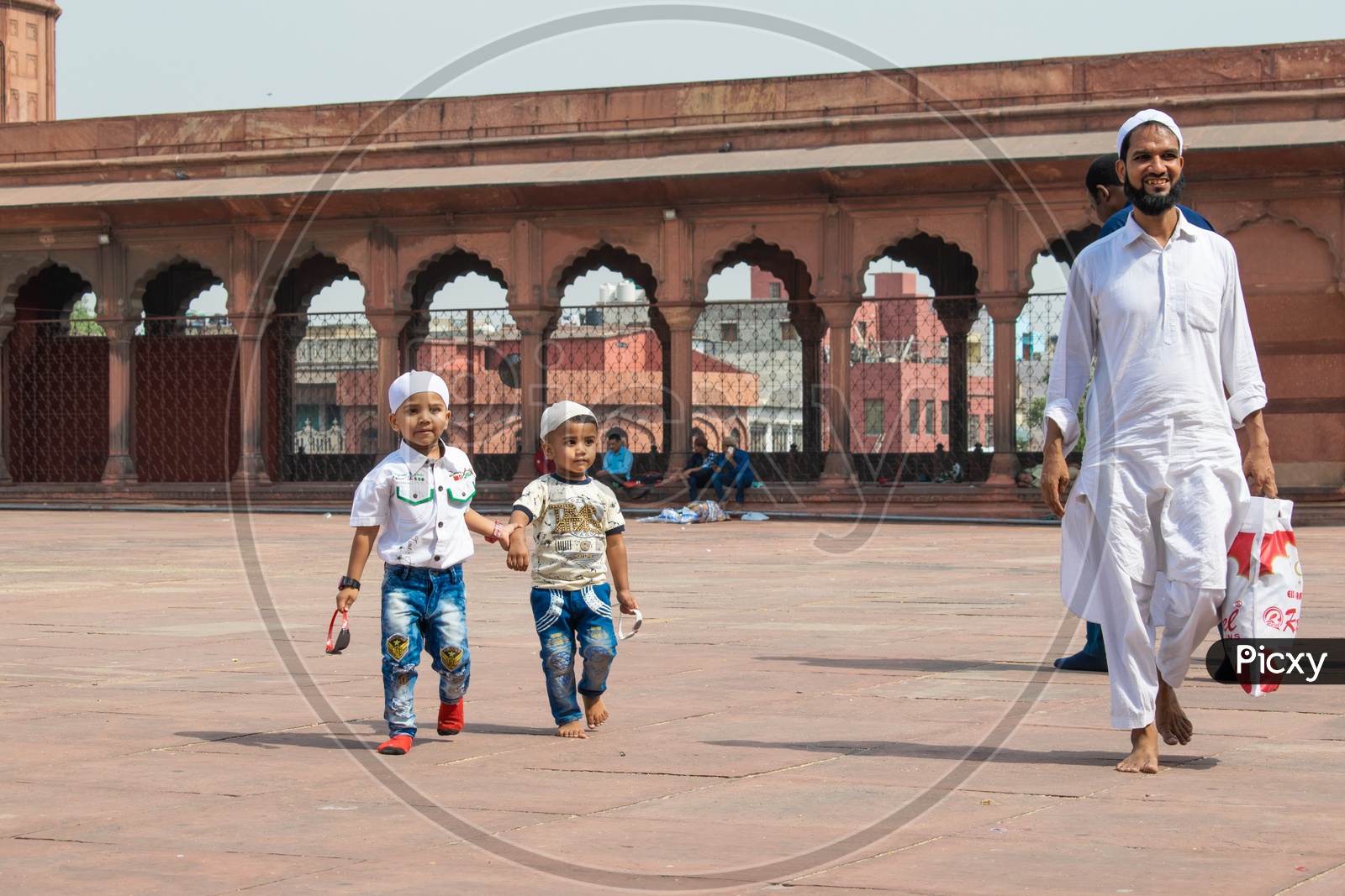 Brothers holding hands and their father on the day of Eid-ul-Fitr (End of the holy month of Ramadan) at Jama Masjid, Delhi