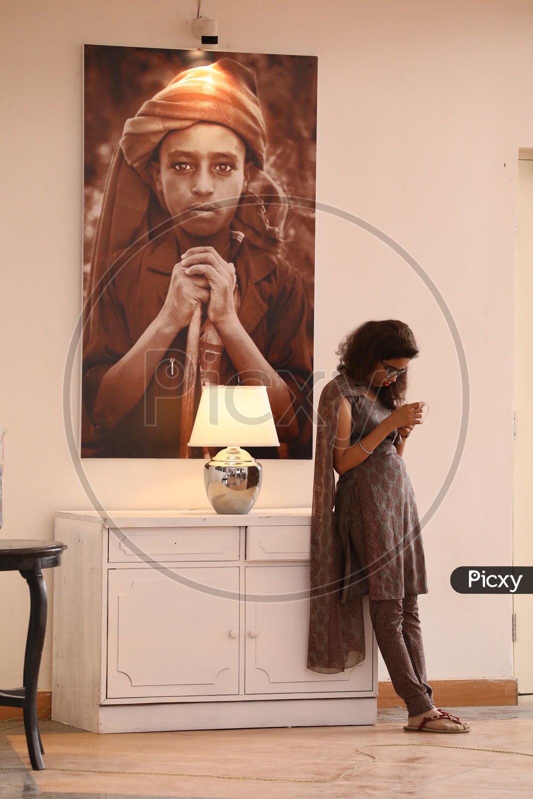 A Young Girl Using Smartphone by Standing In a  Art Gallery
