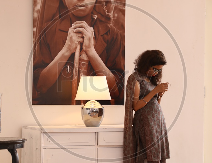 A Young Girl Using Smartphone by Standing In a  Art Gallery