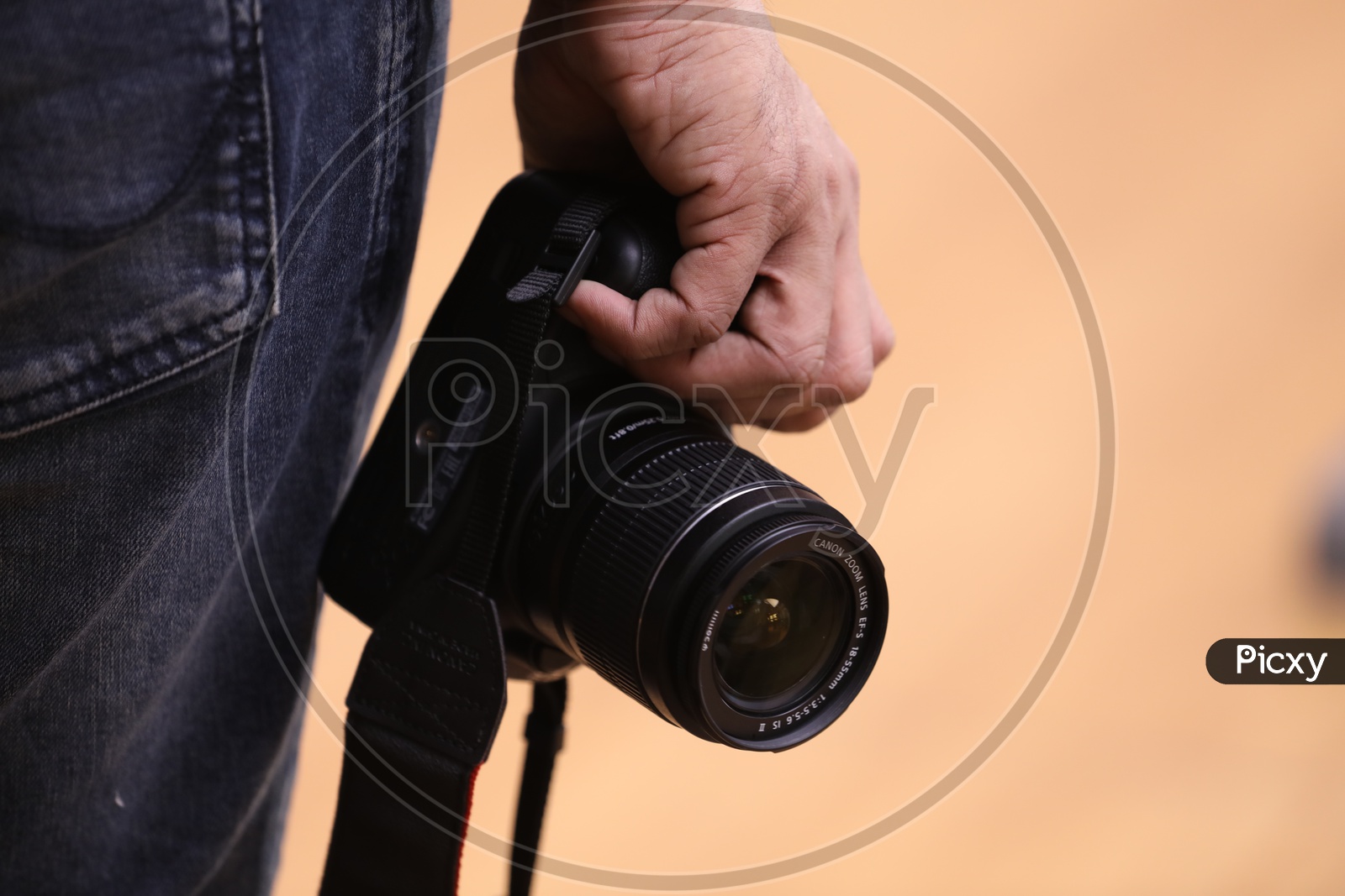 A Photographer Holding a DSLR Camera In Hand Closeup